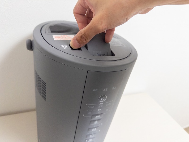 チャイルドロックを解除しながら蓋を開けている写真